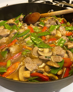 Photo of a skillet of pork and vegetable stir-fry on the stove