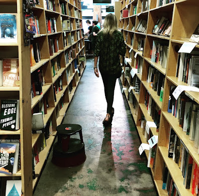 Powell's Books Bookstore with Woman Walking through Bookshelves