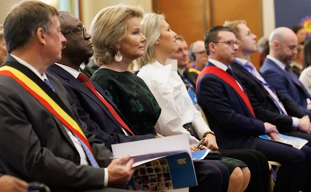 Queen Mathilde wore a forest green printed dress by Dries Van Noten. Tikli Jewelry gold earrings and bracelet