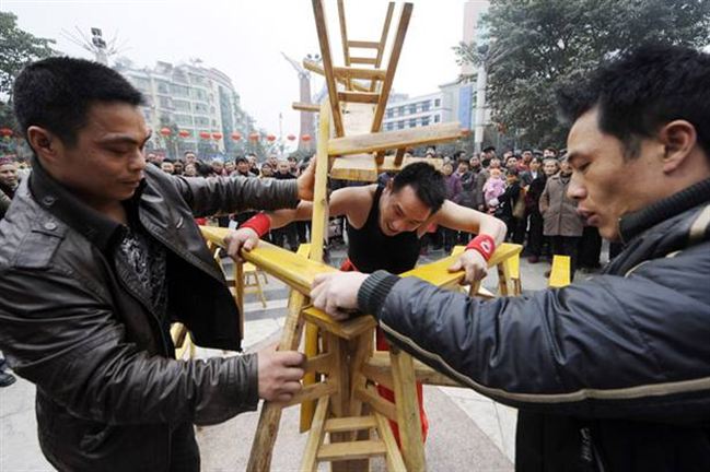 Li Hongxiao Angkat 23 Kursi Kayu Dengan Giginya [ www.BlogApaAja.com ]