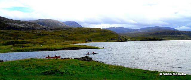 On the banks of Loch Assynt, a lake in the North-East Highlands of Scotland, are two ruins. Both of them are in advanced stages of decay and have very interesting stories linked with them.First of them is the Calda House, which was constructed in the 18th century by the members of the Clan Mackenzie. The house once used to be a three storied abode that burnt down after a lightning strike apparently because the occupants continued to celebrate on the Sabbath day of the Lord. Looking at the state of the house today, one would guess the age of the building to be much more than only a couple of centuries.This is how the Calda House would've looked when it was still inhabited and not burnt down. Look at the detailed maps. Each floor has at least 6 rooms. Sometimes it is difficult to perceive how something as big as a house can be annihilated by a local fire. Hmm. Anyways, the house is allegedly haunted by several ghosts now. I was just imagining how the area would look after the day lights faded. There were no apparent arrangements for artificial lighting. A sight of the creepy, lonely house standing miles away from any human population is enough to scare anyone. Ghosts are just garnishing.This was where our little bus was parked as well. As you can see, there's not a soul in sight for miles. Sheep don't count. And there are no bright street lights that we expect from a road.And this was how the more famous of the two ruins, the Ardvreck Castle was supposed to look like when it was not in ruins. This building is a little older than the Calda house and is very much in ruins itself as you will see in a few moments. The castle is now a risky building with the masonary ready to jump out at you at the slightest provocation. So care is advised if you visit this monument.  And this was the path we were advised to take. The path wasn't VERY boggy but it was boggy nevertheless. A bog is a wetland that contains peat that is formed by the remains of dead plants. peat is a very important fuel in these regions. The Castle was stationed on a low rocky hill next to the lake. The slippery terrain and the rocks below make this a very difficult picture to take. I think I was a little foolish to attempt this picture. Don't follow my example please. The area doesn't need any more resident ghosts. Here is the first view of the legendary Ardvreack Castle built by the members of Clan Macleod in the 16th century. The structure is imposing even in decay. This was apparently built with the support of the devil and, in exchange, one of the daughters of the Macleods was to marry the Devil. Devastated, the maiden flung herself out of a window of the castle. Her ghost is supposed to haunt the ruins till date. In front our some canoes that provided a good perspective to the picture.This is a small inlet of the Loch Assynt jutting into the castle grounds right next to the magnificient ruins. The water was clean yet grey because of the poor lighting.A view of the seemingly placid Lake Assynt from a hill on its bank. Some of the white dots in the distance are sheep grazing.A sample of what the view from the castle's windows would've been like. I wonder how people who lived in such beautiful surroundings could be so cruel to each other. Scotland's history is so full of anger, violence, hatered, and betrayal, that it isn't surprising that so many Ghosts continue to haunt these regions.My friend Andy from Taiwan clicking a risky picture.  And in the distance, visible through the window are some of our tour companions. Me and Andy were often the last ones to get back to the bus. But we were definitely a disciplined batch because we still made it in time. The canoes are finally out on the Lake. The temperatures were quite low so I bow to the courage and passion of these sailors.And here is the castle up close. Quite imposing, isn't it?