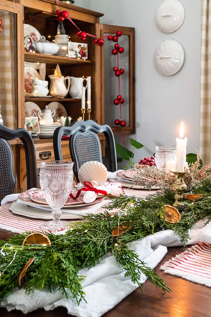 Christmas dining table with red and white, greenery, dried oranges