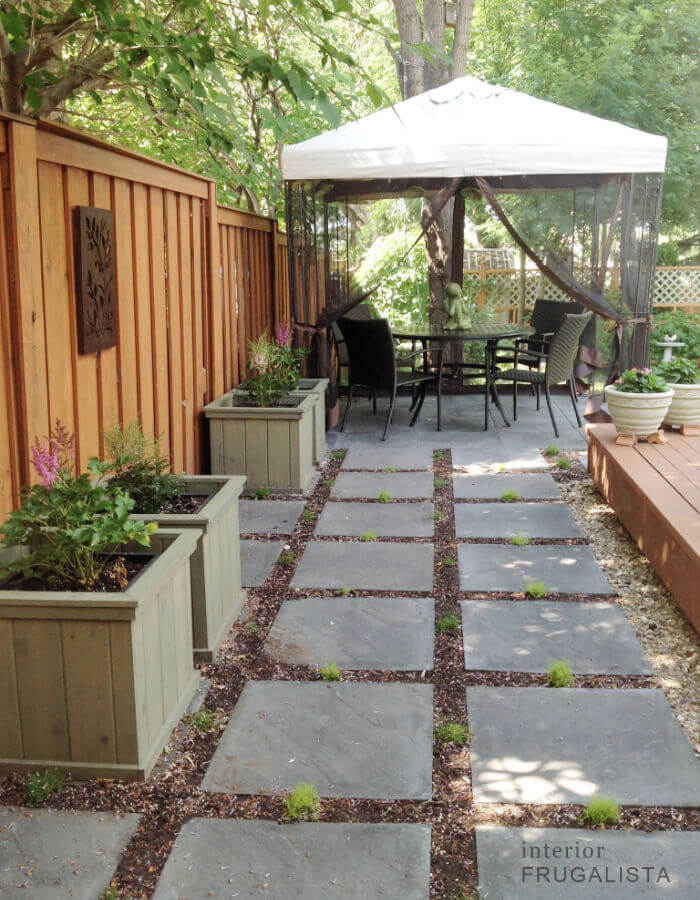 A grid-style budget-friendly DIY paver block patio with moss ground cover.