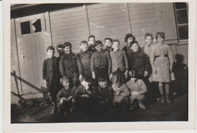 Elèves de la classe de cours moyen/fin d’études de Campénéac, 1951, photographie prise par M. Quinio, leur instituteur, devant la « baraque » qui leur sert de local (collection musée)