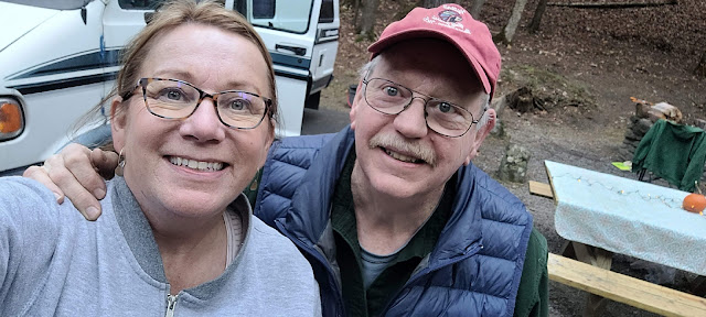 Woman with hair pulled back and glasses and man with red ballcap and glasses.