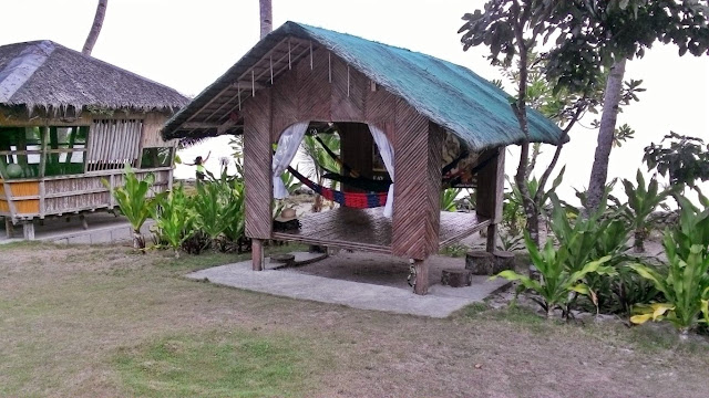 view of the hammock cottage and Ilang-ilang cottage amidst the grass lawn and the seat in the background at EWP Island Beach Resort in San Antonio, Dalupiri Island, Northern Samar