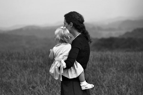 Una madre sujeta en brazos a su hija.