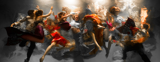 A photograph that looks like a painting containing aproximately ten people captured in underwater movement, all full dressed, their clothes swirling around them, and bubbles rising up. Their clothing is a variety of bright colours and varying style. Created by artist Christy Lee Rogers.