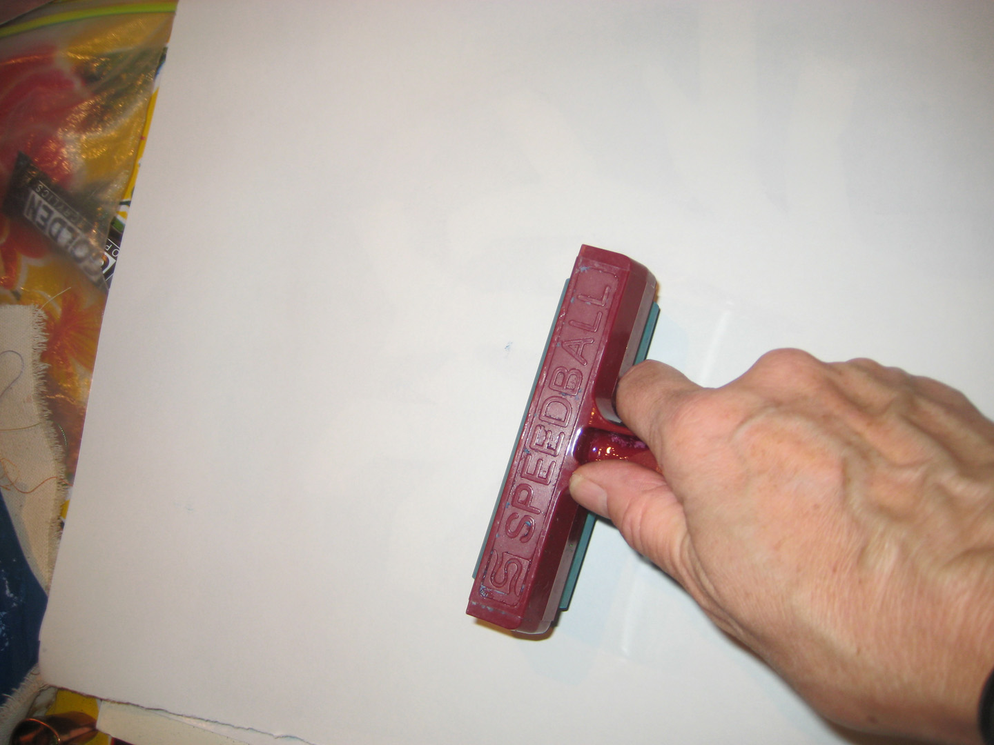 piece of paper on top of the painted plexiglas, and brayer over ...