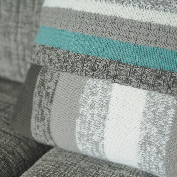 Marled grey section of knitted cushion on grey sofa