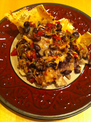 Tasty plate of black bean nachos with melted cheese and home made pico salsa