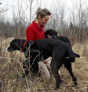 Kristi Benson in a field with two of her dogs. Spot the eyebrows?