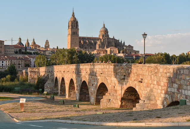 Ponte Romana de Salamanca na região de Castilla e León em Espanha. Por trás a Catedral Velha e Nova de Salamanca e a Universidade Pontificia. Rio Tormes