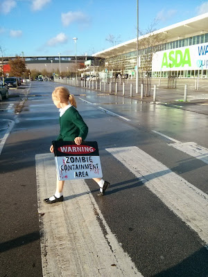 Top Ender carrying a Zombie Containment Area sign in Asda car park