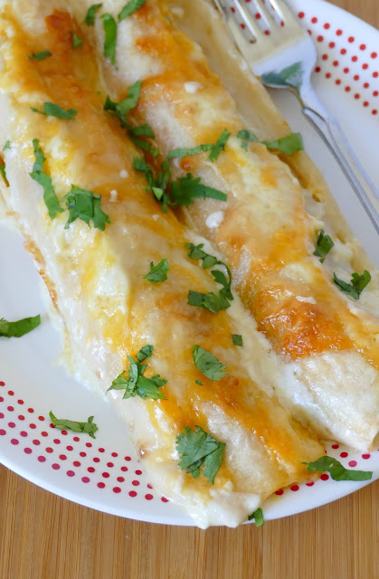 These chicken enchiladas are full of creamy, cheesy goodness! Perfect for Sunday dinner and sure to be a new family favorite! Use rotisserie chicken to save time in the kitchen!
