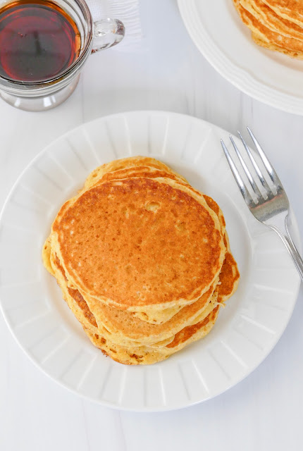 stack of pancakes on a white plate.