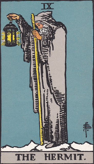 Old man with grew robe holds a lamp with a star inside and a rod on his other hand in a dark night