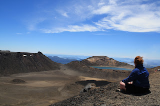 Jenn sitting cross-legged, looking at the crater lakes.