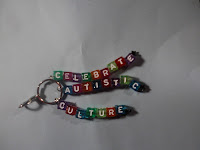 3-stranded keychain that says "celebrate autistic culture" in rainbow letters