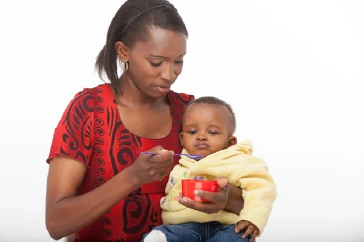 BLACK WOMAN FEEDING HER BABY