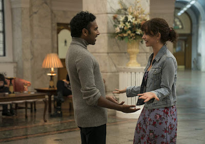 Jack Malik (Himesh Patel) and Ellie (Lily James) are reunited in a hotel lobby in a movie still for the film Yesterday