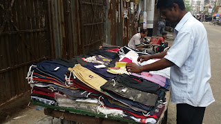 A clothing vendor and street tailor outside the Wari School