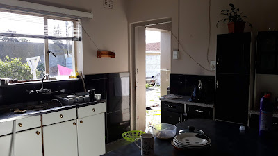 large open plan kitchen with tiled floors and built-in-cupboards