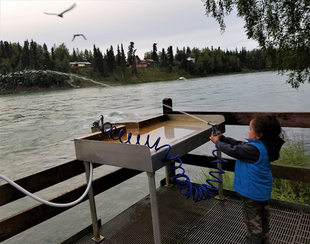 Boy with water hose at a Fish Cleaning station