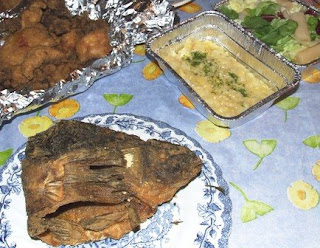 Gebackener Spiegelkarpfen auf Teller, Ingraisch, Kartoffelsalat und anderer Salat in einer Transportverpackung