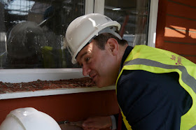 Ed Davey, Energy Secretary, learning how to insulate solid walls.