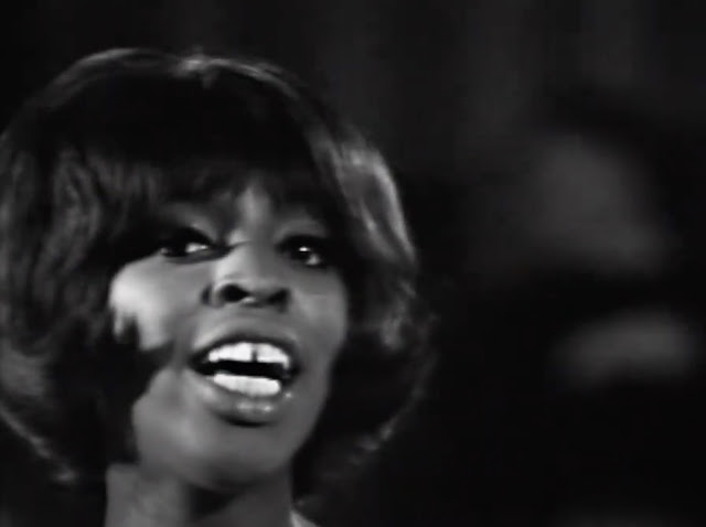 Close up of Madeline Bell singing.