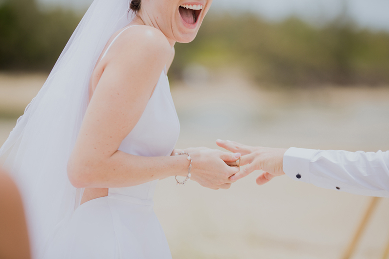 bride laughing at groom wedding ring stuck