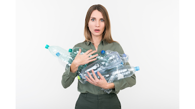 woman holding lots of plastic bottles