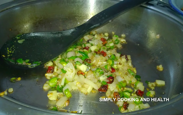 Onion,green chili, red chili and garlic are frying in a large non-stick saucepan