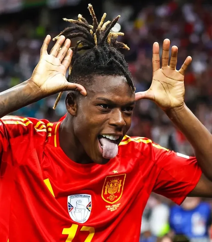 Nico Williams  Jogador de futebol da Espanha com penteado dreadlock e expressões divertidas durante uma partida, vestindo uniforme vermelho com escudo da seleção espanhola.