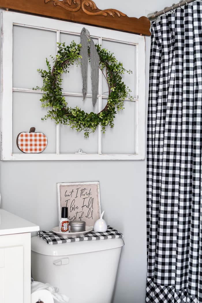 black and white check shower curtain, vintage window, wreath, pumpkin