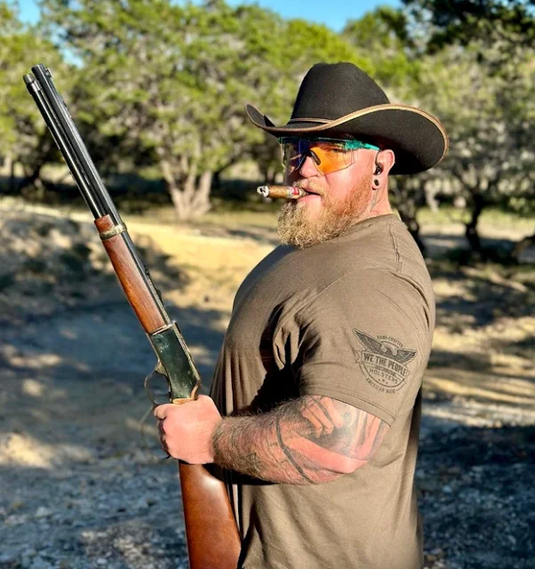 1/2 big-bellied cowboy hat wearing redneck smoking a stogie while shooting a rifle