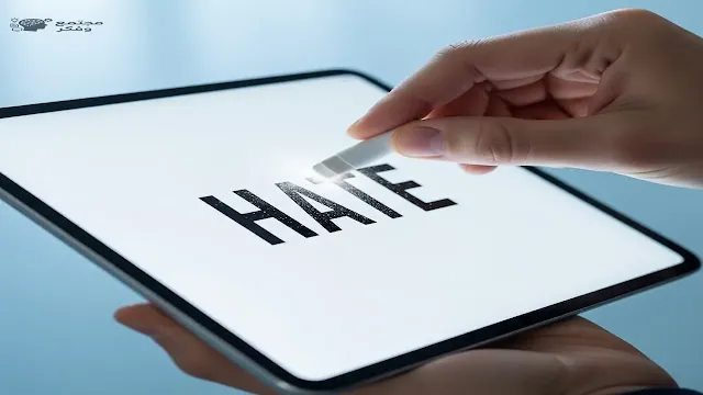 يد تمحو كلمة 'كراهية' مكتوبة على شاشة جهاز لوحي، ترمز إلى مكافحة خطاب الكراهية في وسائل التواصل الاجتماعي.
