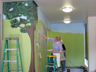 Michelle painting a dog onto the wall