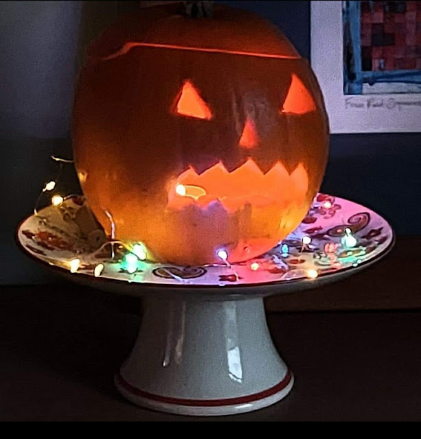 a lit up carved pumpkin at night.