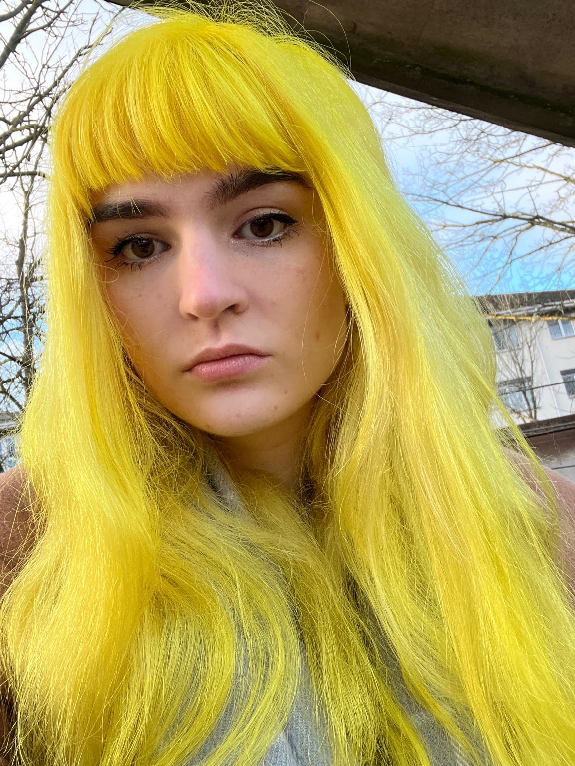 Bleach London Twisted Lemon freshly dyed on long wavy hair in bright natural light