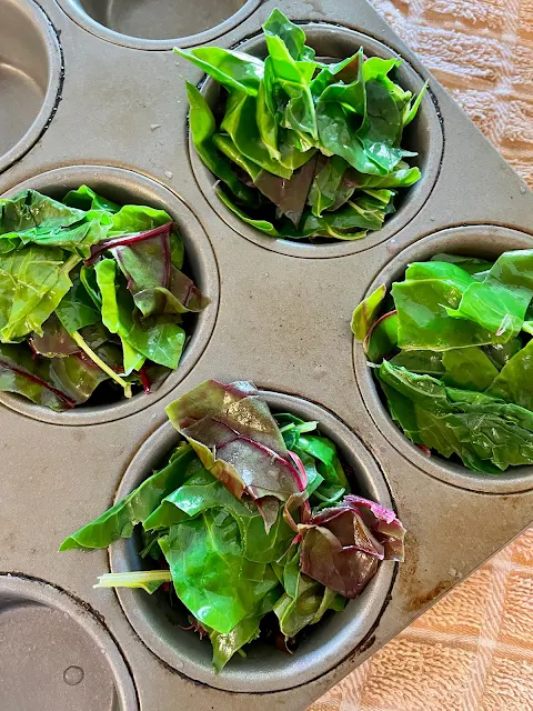 Swiss chard leaves in a muffin to for freezing.