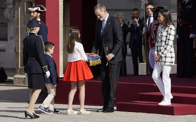 Queen Letizia wore a black and white houndstooth blazer by Uterque, white trousers by Hugo Boss, white air force sneakers by Nike