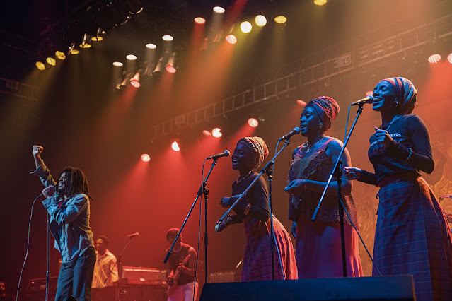 A man and three women perform on a music stage