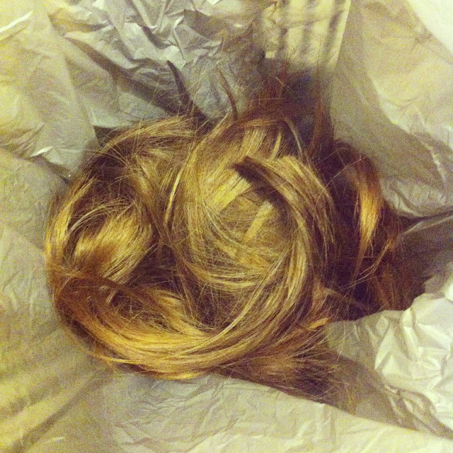 Photo of the hair I cut off inside a grey plastic shopping bag.