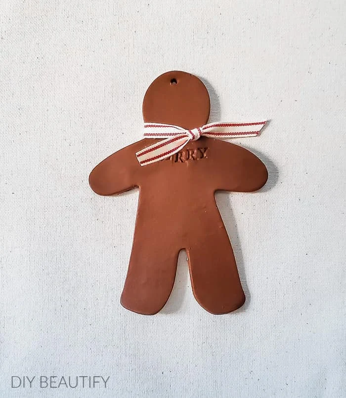 clay gingerbread man with red striped bow