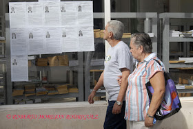 Dos personas observan las fotos y biografías de los candidatos al Parlamento Cubano expuestas en la calle Obispo, en La Habana, Cuba.