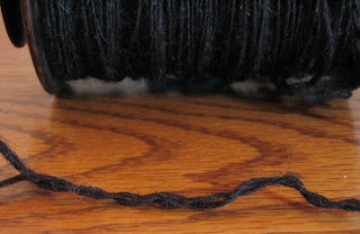 A bobbin of Black Welsh singles, showing it's lack of twist energy.