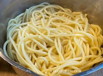 cooked bucatini pasta in a saucepan