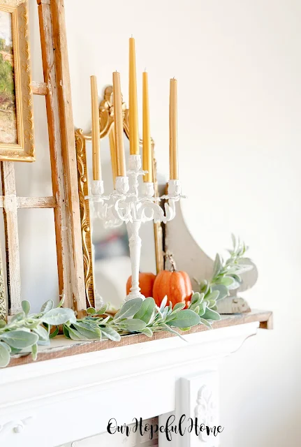 candelabra on mantel with pumpkin and lams ear garland.